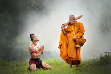 Thai ancient warriors pay respect to Buddhist old monk in the forest.
