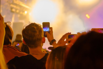 Fototapeta na wymiar Concert visitor shoots video on a smartphone