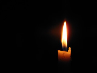 Candle flame closeup black background space for message or icon