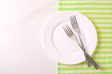 Food background. White empty plate, cutlery, napkin. Top view, copyspace.