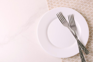 Food background. White empty plate, cutlery, napkin. Top view, copyspace.