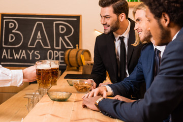 businessmen drinking beer in bar