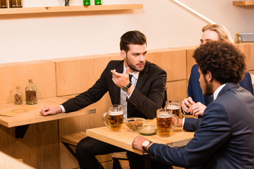 businessmen drinking beer in bar