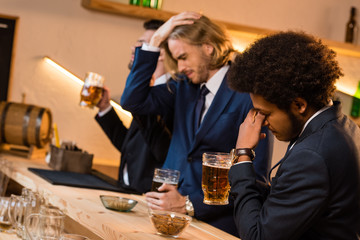 businessmen drinking beer in bar