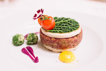 Tasty steak tar tare of raw minced meat. Classic steak beef tar tare with egg on white plate. Raw meat with piece of fresh bread