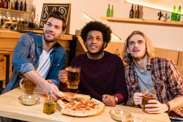 friends with pizza and beer in bar