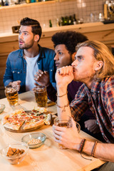 friends with pizza and beer in bar