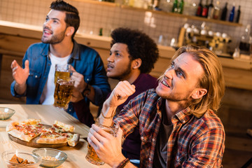 friends with pizza and beer in bar