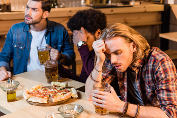 friends with pizza and beer in bar