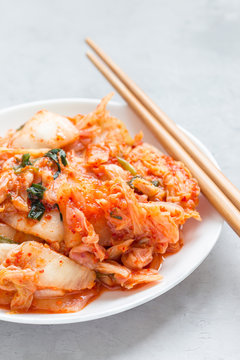 Kimchi cabbage. Korean appetizer on white plate, vertical