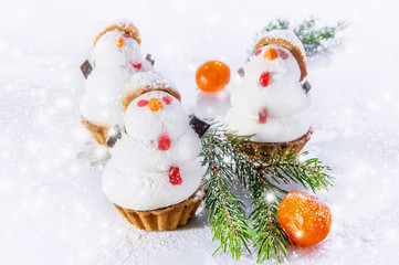 Three white snowman from marzipan and meringue on the Christmas table. Selective focus.