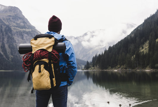 Austria, Tyrol, Alps, hiker standing at mountain lake