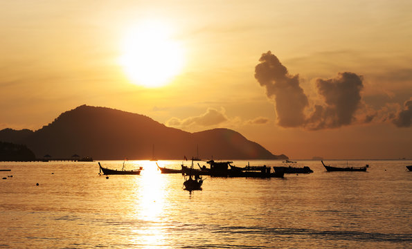 Fototapeta Beautiful sunrise seascape view with boat,rawai beach in phuket island.