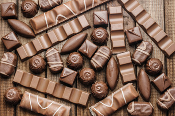 Background of chocolates, bars and sweets, free space for text, close up