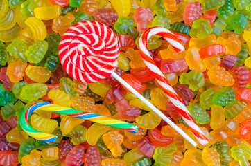 background of many bright and colored jelly sweets with free space for text, top view