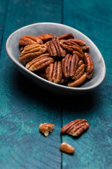 Pecans on petrol-colored wood in shell