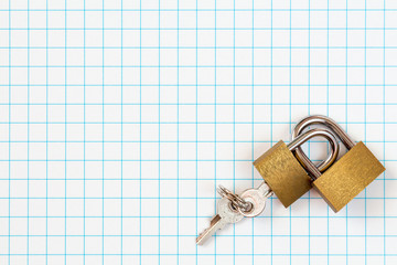 Two linked padlocks lying on square paper