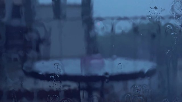 Rainy days in autumn season. Heavy storm rain showers on window pane surface. Raindrops on glass.