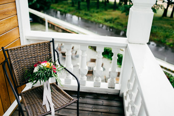 Chair with beautiful bouquet on balcony