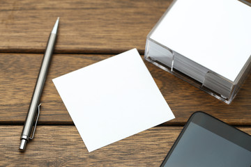 blank notepaper,pen,and smartphone on vintage wooden table