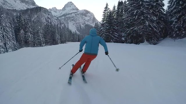 Skier running downhill on piste, slow motion