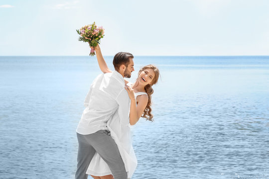 Happy newlywed couple on seashore