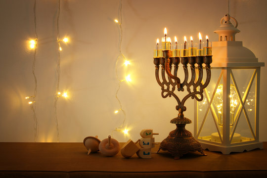 Low key image of jewish holiday Hanukkah background with traditional spinnig top, menorah (traditional candelabra)