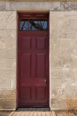 Dark red wooden entrance door. Front view.