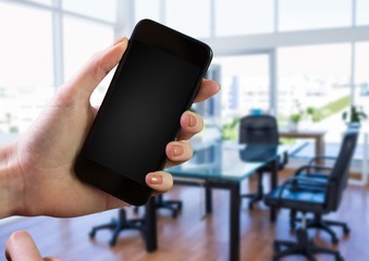 Hand using phone with office background