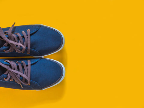 Blue sneakers on yellow background