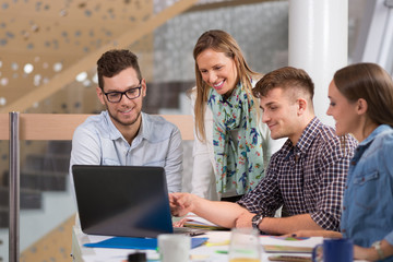 Fototapeta premium Team of smiling business people using laptop on business meeting