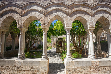 Fototapeta na wymiar Some tourists visit the cloister of the monastery of San Giovanni degli Eremiti in Palermo, Italy