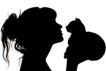 silhouette of a beautiful woman with wavy hair that nose to nose with a small kitten in her arms,...