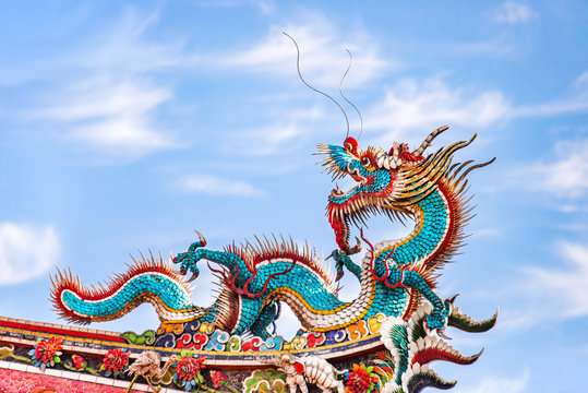 Beautiful dragon crawling on the decorative tile roof in Chinese temples. Colorful roof detail of traditional Chinese temple