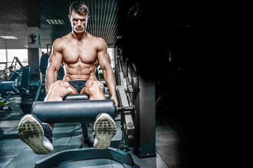 Fototapeta na wymiar Handsome model young man training legs in gym