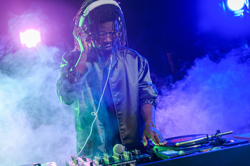 DJ in headphones with sound mixer - obrazy, fototapety, plakaty