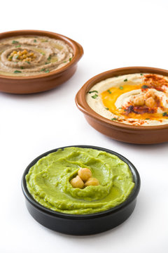 Different hummus bowls. Chickpea hummus, avocado hummus and lentils hummus isolated on white background