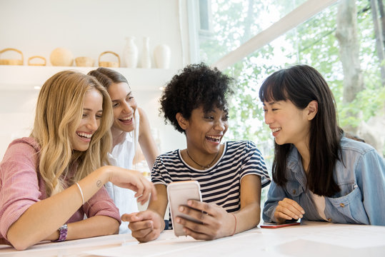Young women looking at smartphone and laughing together