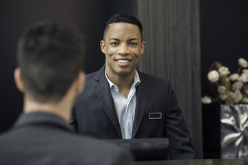 Man standing behind bank teller counter