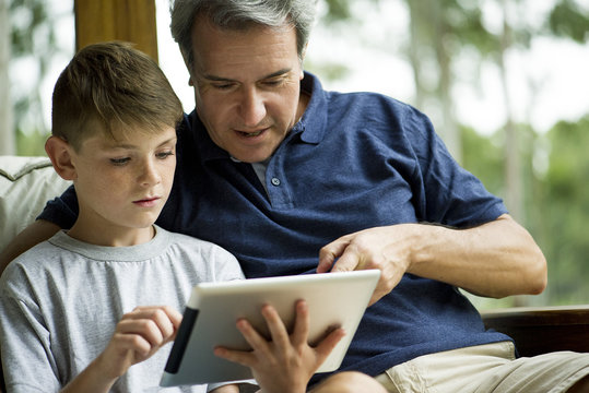 Man with child using digital tablet