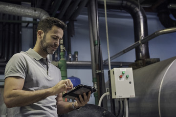 Man using digital tablet in industrial setting