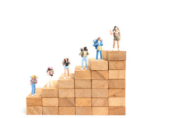 Miniature people: Backpacker standing on wood block isolated on white background, Travel concept