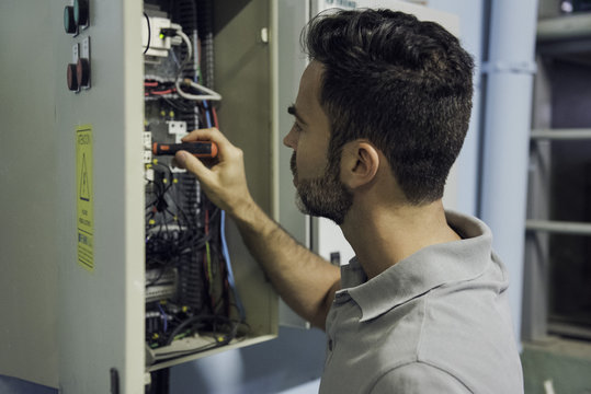 Man working in electrical control cabinet