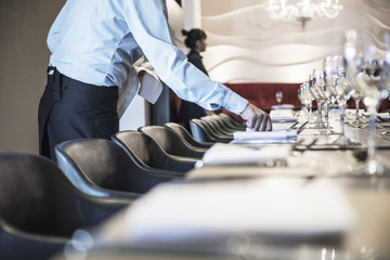 Waitress setting table in restaurant