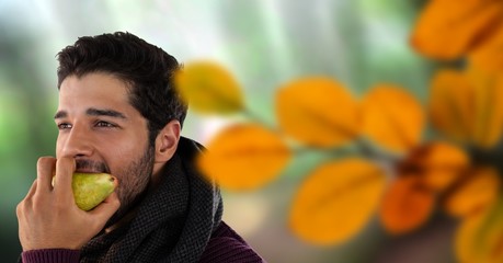 Man's face in forest with leaves eating apple