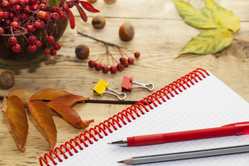 Naklejka na ściany i meble notepad on the spring and pens, wooden countertop, autumn still-life