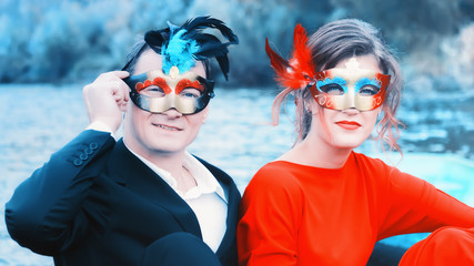 Fototapeta na wymiar Couple In Masquerade Masks At A Lake