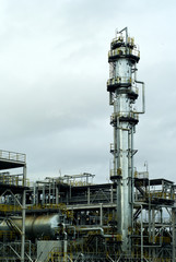 Section of the distillery plant of a modern oil refinery with a fractionating column, tanks and...