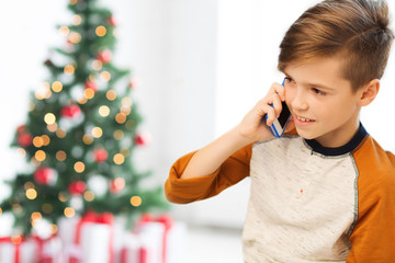 boy calling on smartphone at home at christmas
