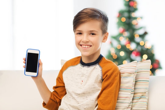 boy with smartphone at home at christmas